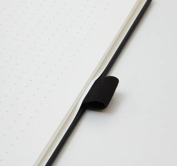 Elastic pen loop beside a dot-grid page